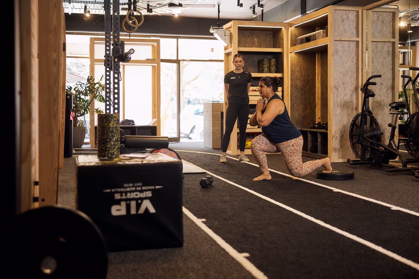 Client pausing at the bottom of a squat on the Adapt training floor, North Sydney